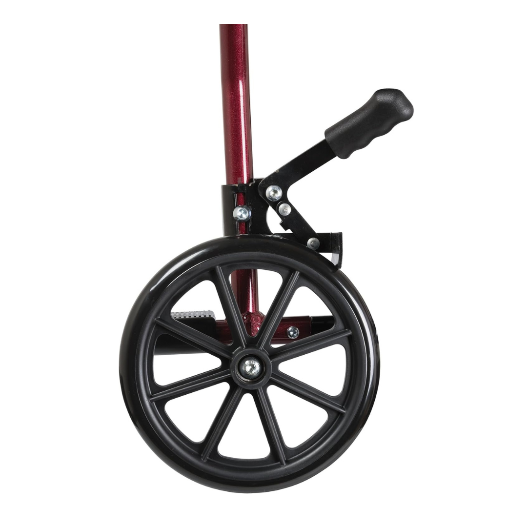 Close-up of a black wheel with spokes on the metallic red frame of the ProBasics Aluminum Lightweight Transport Chair, featuring a black hand brake lever above the wheel against a white background.