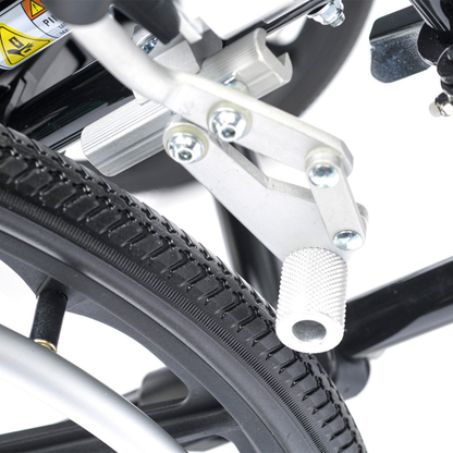Close-up of the Proactive Chariot IV XTC Pediatric Wheelchair brake mechanism, showing the metal lever with textured grip and bolts pressed against the black tire, securely attached to the wheelchair frame.