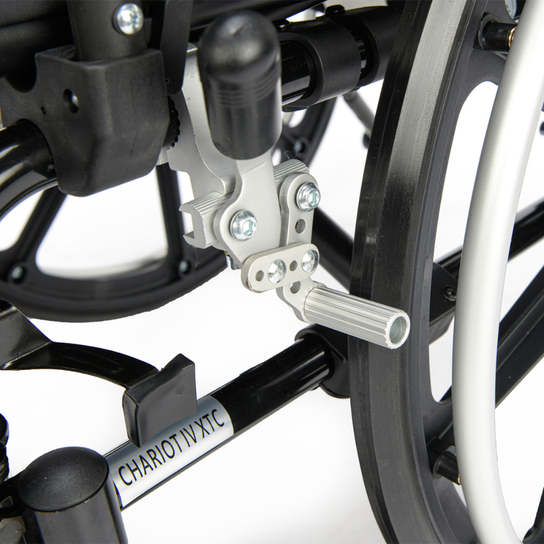 Close-up of the metal frame and mechanical parts of the Proactive Chariot IV XTC Wheelchair with Adjustable Seat Depth, showing its footrest and product label near the wheel.