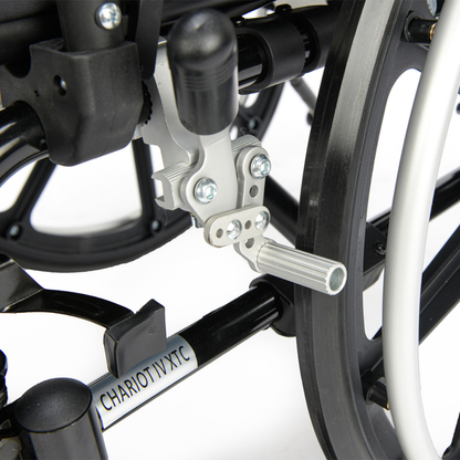 Close-up of the metal frame and mechanical parts of the Proactive Chariot IV XTC Wheelchair with Adjustable Seat Depth, showing its footrest and product label near the wheel.
