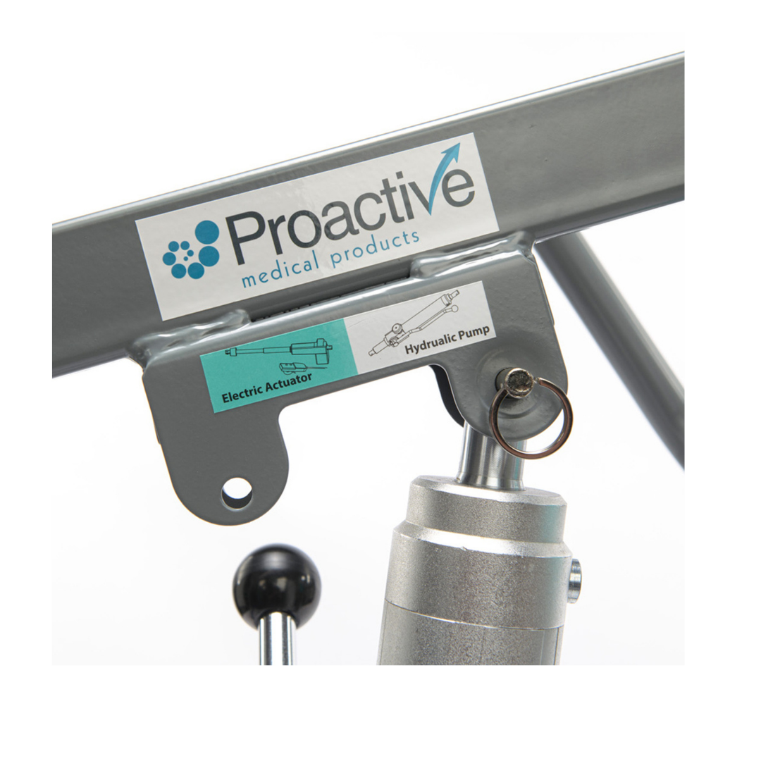 Close-up of a Proactive Protekt® Transformer Hydraulic or Powered Patient Lift, featuring a metal frame labeled “Electric Actuator” and “Hydraulic Pump,” with visible diagram, key ring, and mechanical parts for homecare patient transfer.