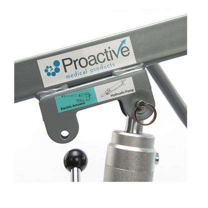 Close-up of a Proactive Protekt® Transformer Hydraulic or Powered Patient Lift, featuring a metal frame labeled “Electric Actuator” and “Hydraulic Pump,” with visible diagram, key ring, and mechanical parts for homecare patient transfer.