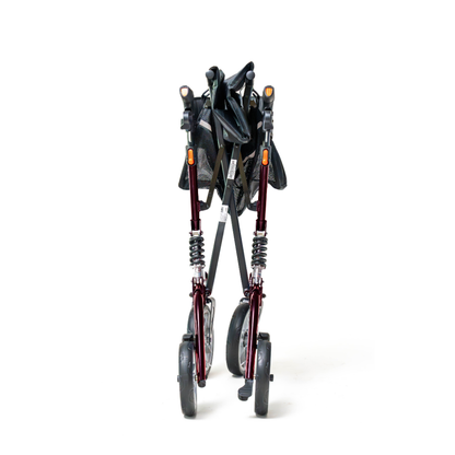 The Probasics Ascent XR™ Euro-Style Bariatric Rollator with Suspension, a foldable heavy-duty walker with shock-absorbing suspension and four wheels, is shown collapsed with a dark frame and black seat against a plain white background.