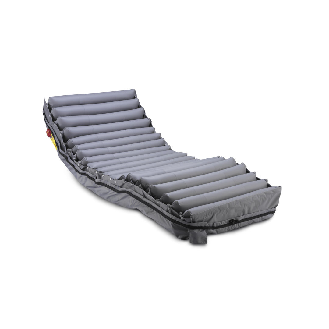 A gray, inflatable air mattress with segmented horizontal tubes, designed for medical or therapeutic use, is shown partially elevated against a white background. This Wellell Procare Auto G2 | Alternating Pressure & LAL Mattress System features advanced airflow technology to deliver effective pressure relief and enhanced comfort for patients requiring additional support.