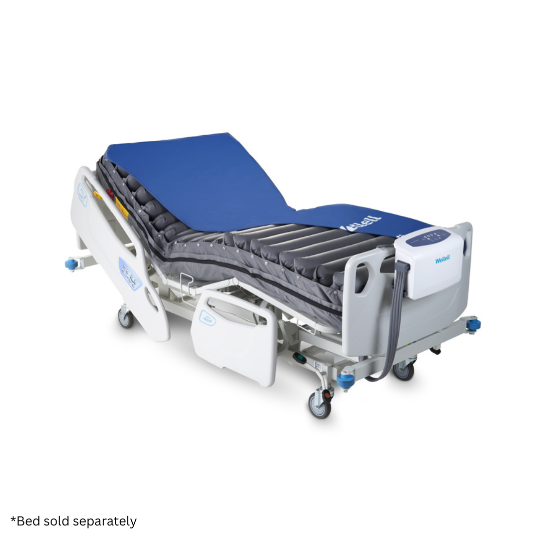 A hospital bed with a Wellell Procare Auto G2 Alternating Pressure & LAL Mattress System, blue mattress cover, white control unit, adjustable side rails, and wheeled base. Text at bottom reads: *Bed sold separately.