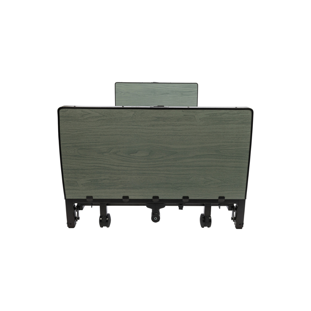 A foldable table with a green wood grain surface and black legs—displayed in a side view with wheels at the base—is an excellent complement to the Protekt Akra-FE™ Full-Electric Bariatric “Low” Bed for use in a homecare environment.