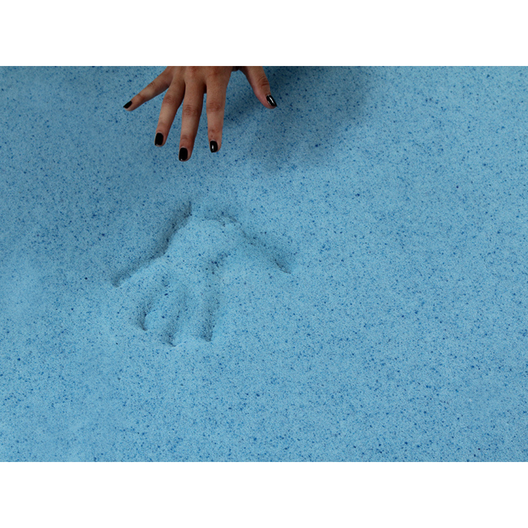 A hand with black nail polish hovers above a light blue sandy surface, next to a handprint—evoking the comfort of the Protekt® Seat Relief Alternating Pressure Seat Cushion System by Proactive, designed for pressure injury prevention.