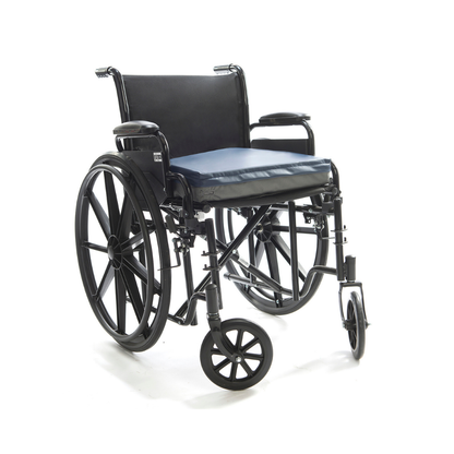 The Protekt® Seat Relief - Alternating Pressure Seat Cushion System by Proactive is shown on a black manual wheelchair with large rear wheels, small front casters, armrests, and a blue cushion, against a white background.