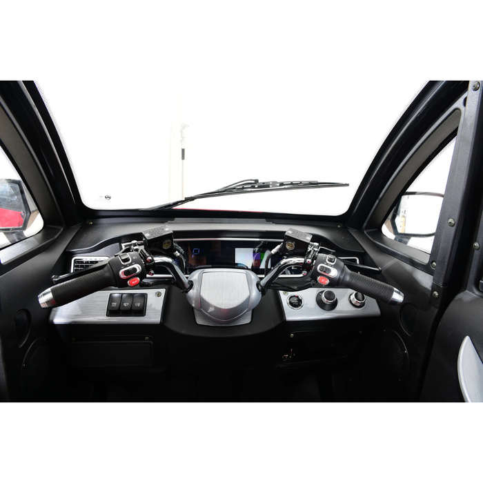 The image shows the cockpit of the Green Transporter Q Express Fully Enclosed Scooter, featuring two joystick-style steering controls, various buttons and dials, a digital display, and a windshield with a single wiper.