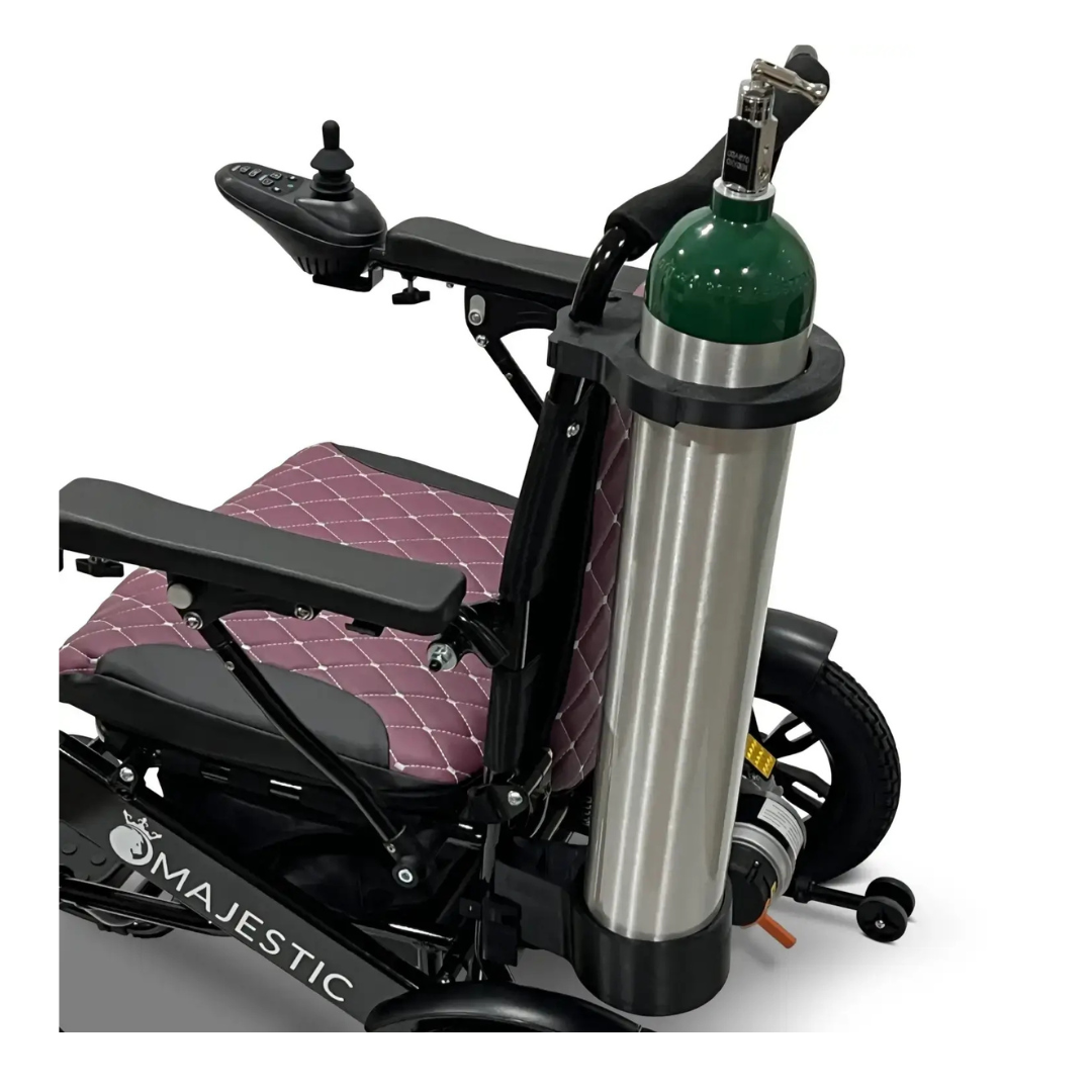A ComfyGo powerchair with a quilted purple seat, featuring a Quick Detach Oxygen E Tank Holder secured at the side and a joystick controller on the armrest.