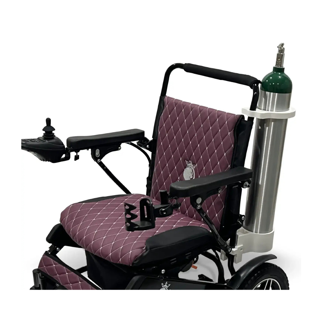 A ComfyGo powerchair with quilted purple cushioning and black armrests, featuring a Quick Detach Oxygen E Tank Holder mounted to the backrest holding a silver tank with a green top.