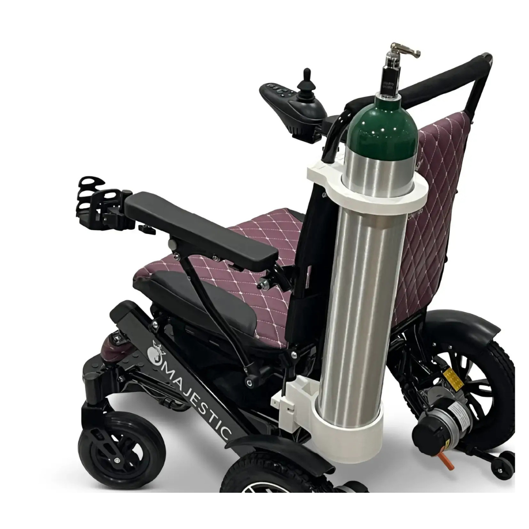 A Quick Detach Oxygen E Tank Holder is mounted on the back of the ComfyGo powerchair with a quilted maroon seat, securely holding a large green and silver oxygen tank.