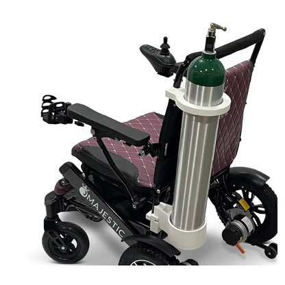 A Quick Detach Oxygen E Tank Holder is mounted on the back of the ComfyGo powerchair with a quilted maroon seat, securely holding a large green and silver oxygen tank.