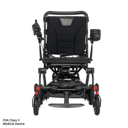 The Rascal® Carbon Cruiser Travel Folding Electric Wheelchair is a black, ultra-lightweight chair with left joystick control, armrests, mesh cup holder, sturdy front wheels, and FDA Class II Medical Device noted on the bottom left. Ideal for travel mobility.