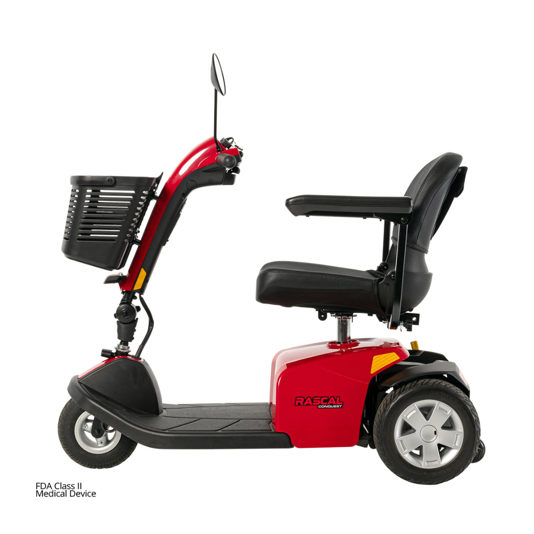 A Rascal® Conquest 3-Wheel Mobility Scooter in red, featuring a black seat with armrests, a front basket, and rearview mirror, is shown from the side on a white background.