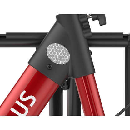 Close-up of a red Rehasense Stylus Premium Indoor & Outdoor Rollator frame with a black joint and silver honeycomb-patterned reflector. A partial white 'S' is visible, with black rack bars in the background—sturdy design details highlighted.
