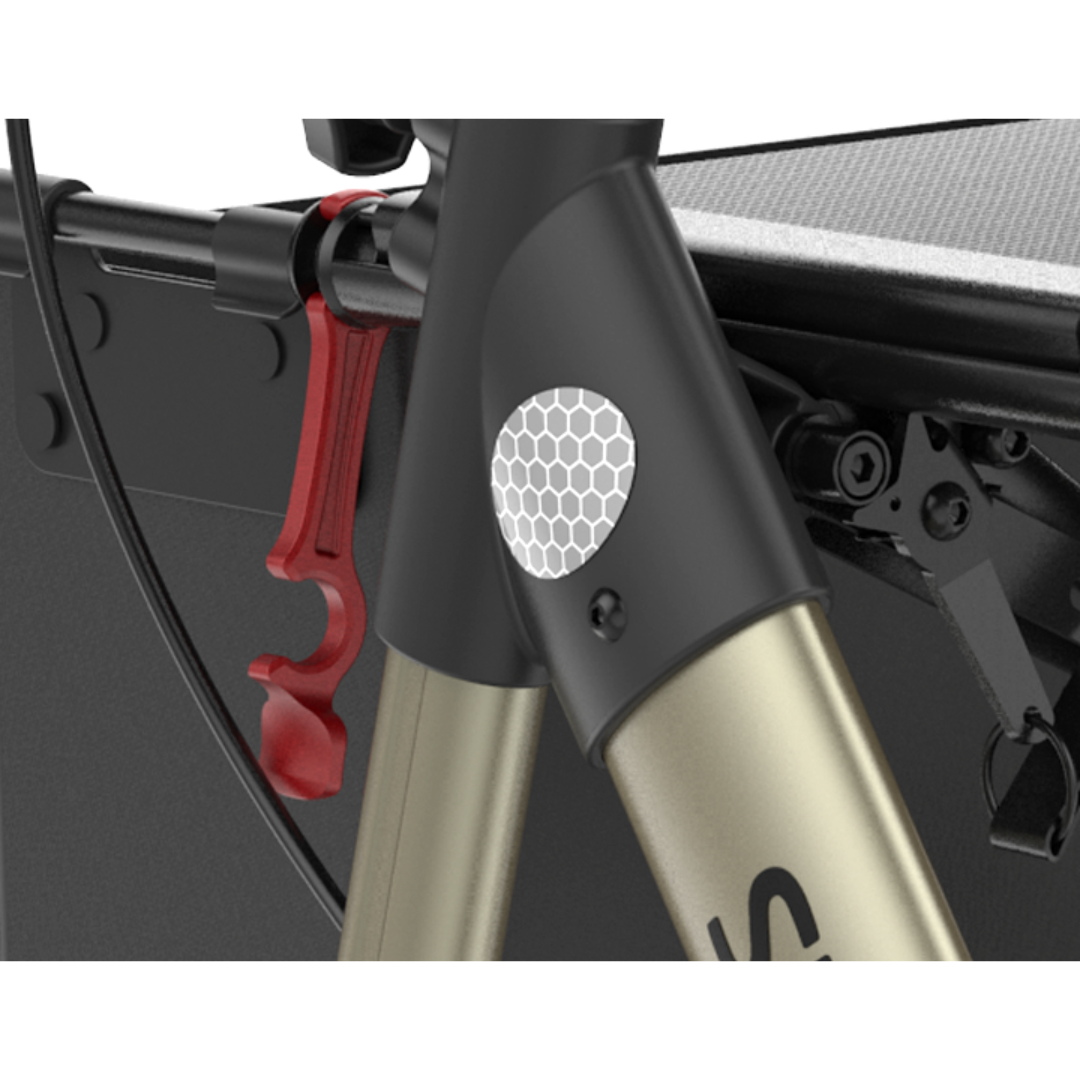 Close-up of a bicycle frame displaying a hexagonal reflector, red clip, cable, and part of a black cargo attachment—features similar to those on the Rehasense Stylus Premium Indoor & Outdoor Rollator.