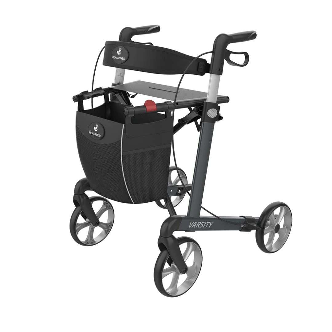 The Rehasense Varsity Folding Aluminum Rollator is lightweight with a foldable black frame, four large wheels, hand brakes, a built-in seat, and a front storage pouch. "Varsity" branding is visible on the frame.