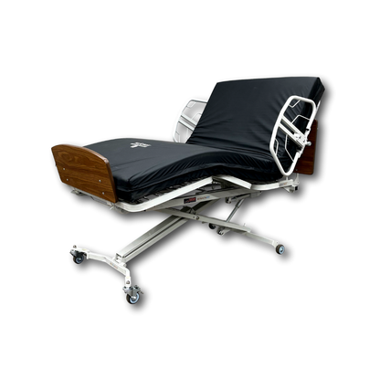 The Med-Mizer RetractaBed Bariatric Hi/Low Electric Bed, featuring a width-adjustable white metal frame, black mattress, wooden headboard and footboard, safety rails, and wheels, is shown against a plain white background.