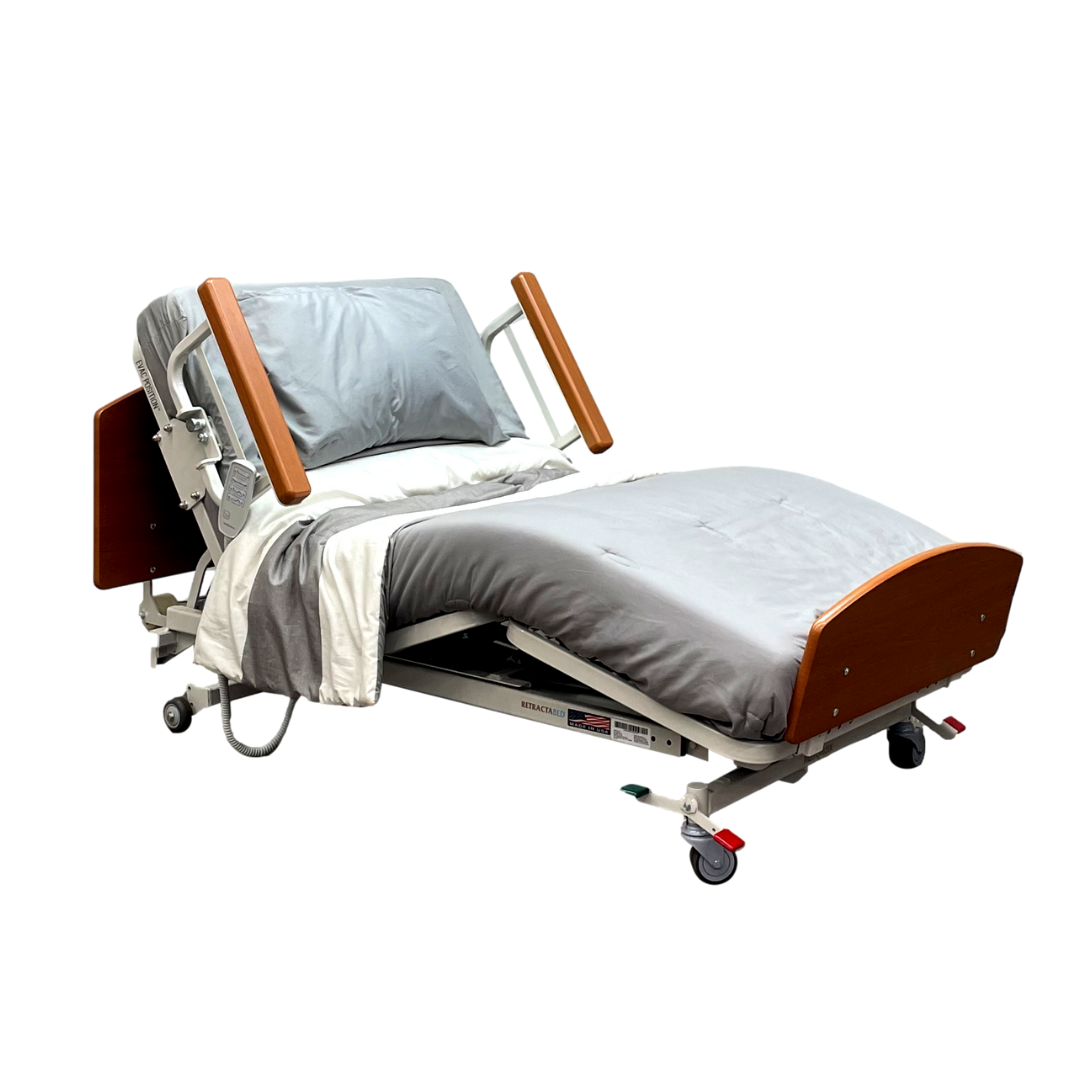 The Med-Mizer RetractaBed Bariatric Hi/Low Electric Bed, featuring width adjustability, gray bedding, adjustable head/foot sections, wooden safety rails, and caster wheels, is shown on a white background.