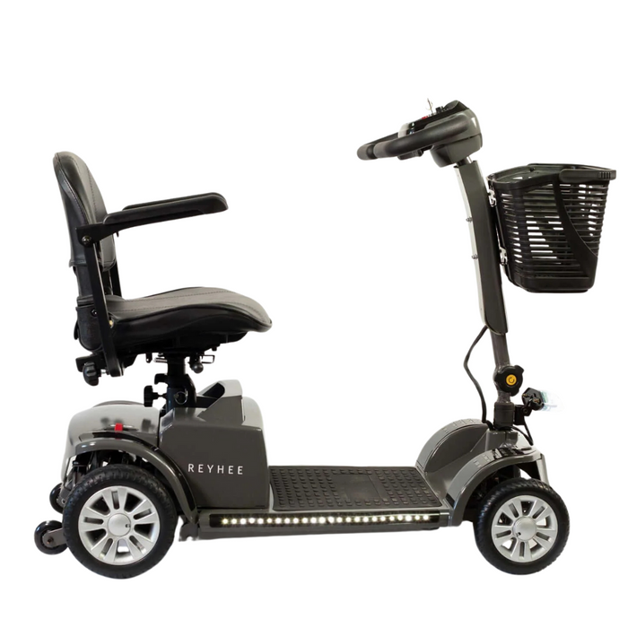 The Reyhee Cruiser Portable Electric Mobility Scooter features a side view with four wheels, cushioned seat with armrests, handlebar with basket, and foldable tiller. The gray scooter showcases REYHEE on the side and includes a sturdy footrest for comfort. FDA-cleared for safety.