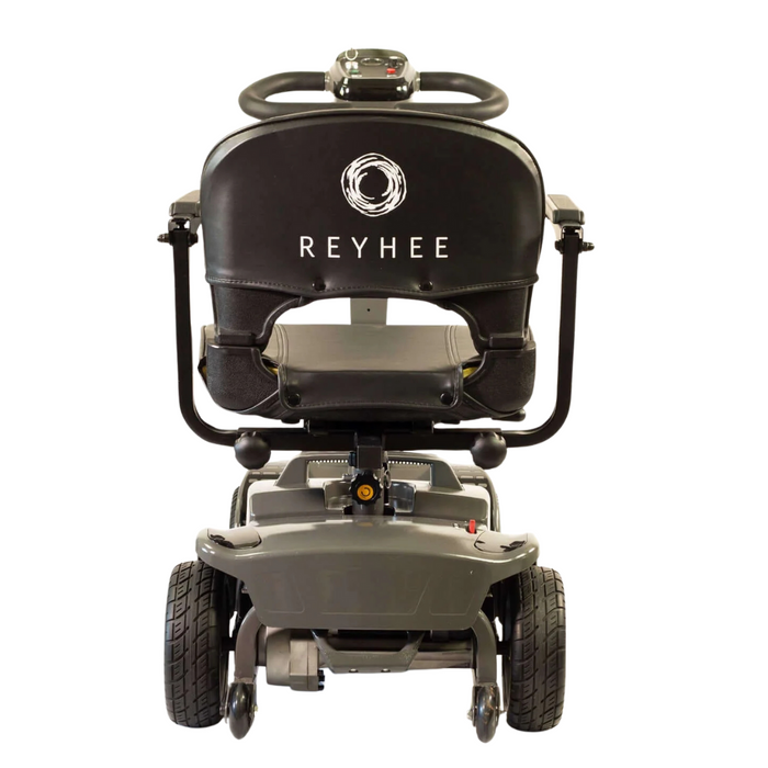 The image shows the back view of the Reyhee Cruiser Portable Electric Mobility Scooter. It features a black seat with REYHEE branding, four wheels, and a compact rear control panel, blending style and convenience for easy navigation.