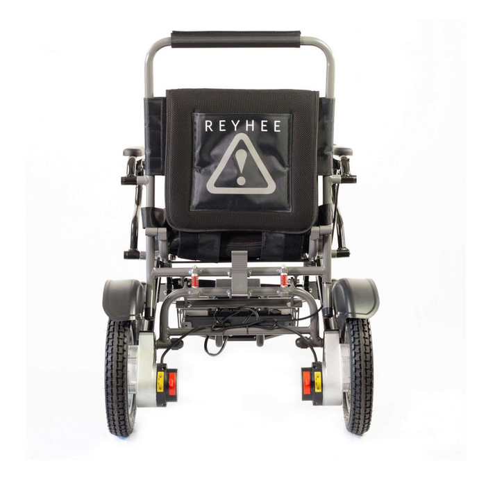 The rear view of a black and gray Reyhee Roamer Folding Long Range Electric Wheelchair features a branded storage pouch with a warning symbol, visible wiring, and mechanisms. This FDA-cleared device has robust, textured tires and sturdy construction.