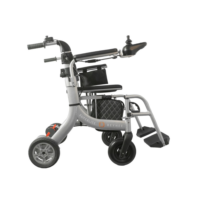 Side view of the Reyhee Superlite 3-in-1 Electric Foldable Wheelchair, a lightweight, travel-friendly model with a silver frame. It has joystick control on the right armrest, a black seat, footrests, large rear wheels, and small front wheels for versatile mobility and stability.