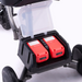 Close-up of the Reyhee Triad Compact Folding Electric Mobility Scooters open battery compartment, showing two red batteries with the Swap & Go Battery System and control panels for easy monitoring. Mounted on a metal frame with black wheels beneath.