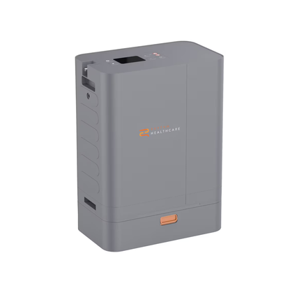The Rhythm Oxygen Concentrator Premium Bundle is a compact, rectangular gray device featuring a small display screen, top buttons, CAIRE Healthcare logo on the front, handle slot, and an orange button near the base.