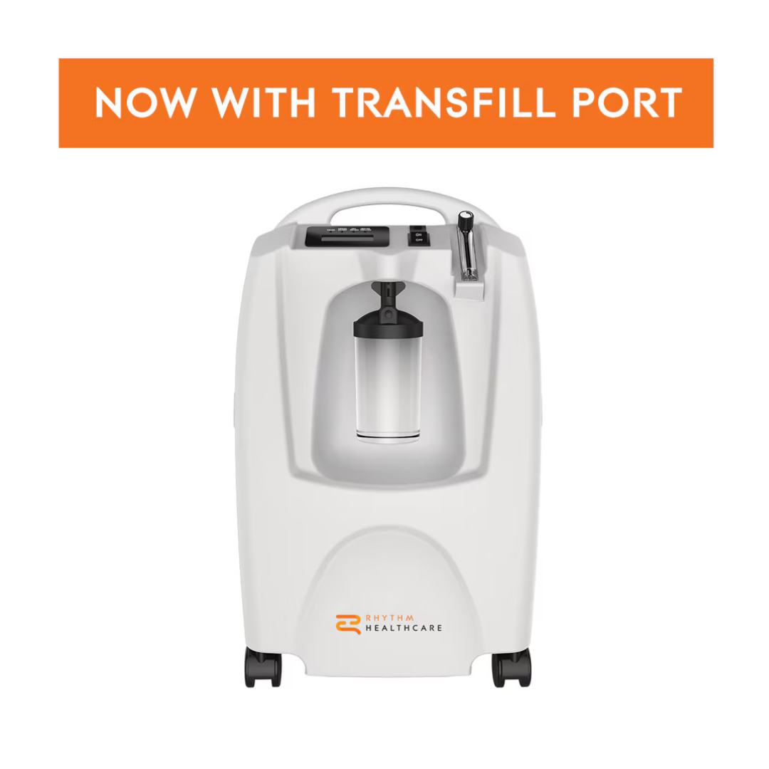 The Rhythm Oxygen Concentrator Premium Bundle is shown with a clear canister, control knob, and front logo. An orange banner above reads “NOW WITH TRANSFILL PORT.”.