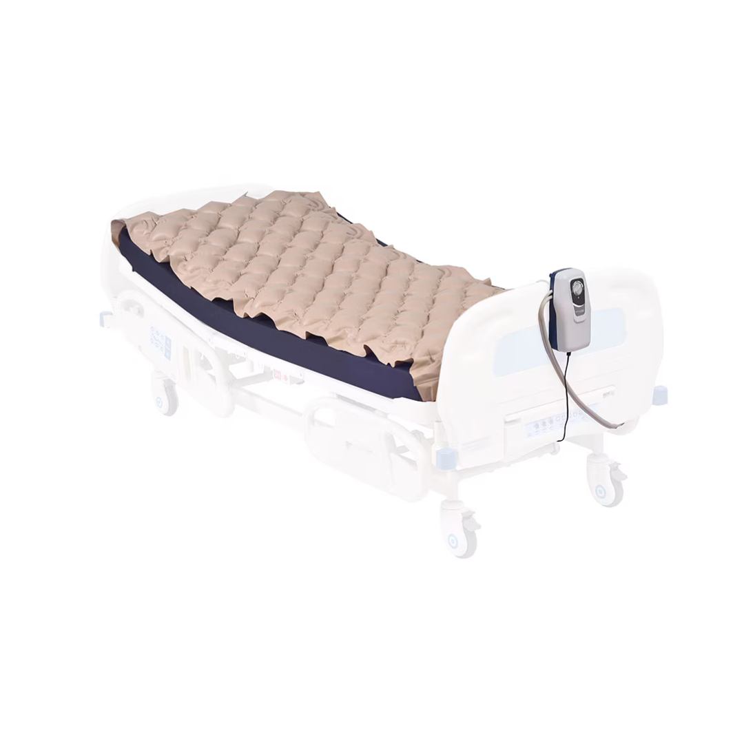 A Rhythm SoftCaire Alternating Pressure Pump and Pad with Flaps is shown on a hospital bed, featuring an inflated beige air mattress overlay and attached pump control unit, isolated on a white background.