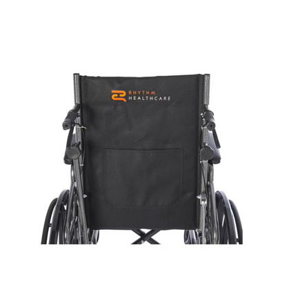 The Rhythm Deluxe Reclining Desk Arm Wheelchair by Rhythm Healthcare features a sleek black design with a back pocket and their distinctive orange and white logo on the backrest. It is equipped with a chrome frame, elevating leg rests, and easily noticeable quick-release rear wheels.