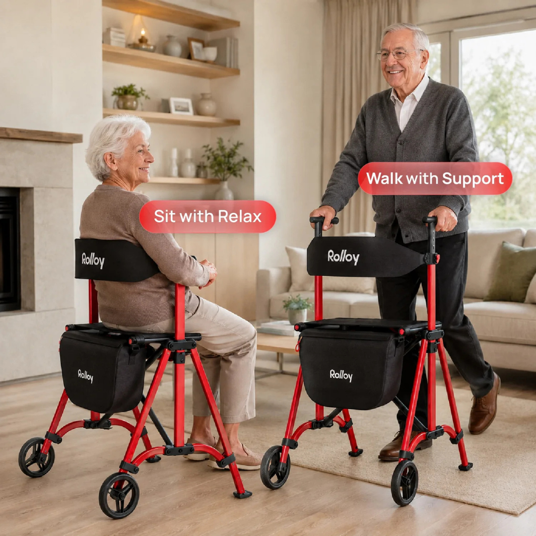 An older woman smiles while seated on a red Rolloy Compact Master Bariatric 2-Wheel Walker with Seat, as an older man stands nearby in a cozy living room.