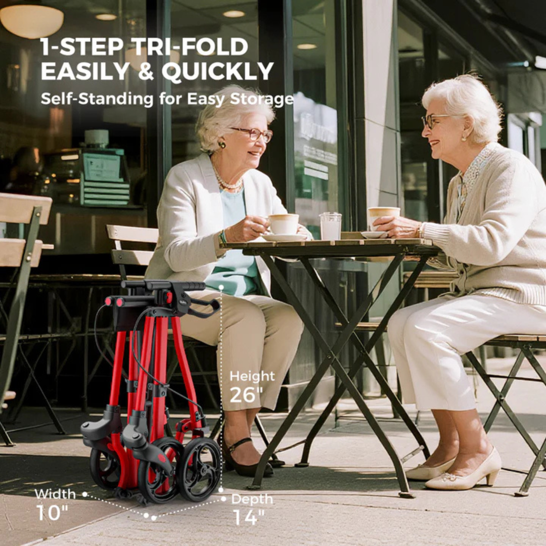 Two older women smile and enjoy coffee at an outdoor café. In the foreground is a folded Rolloy Ultra Compact Master Rollator Walker, labeled with dimensions: height 26", width 10", depth 14".
