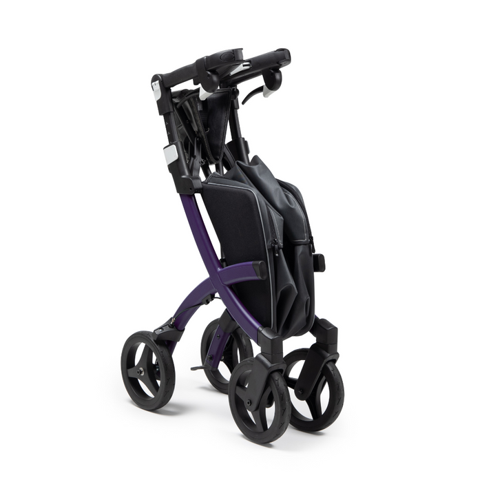 The Rollz FLEX 2 Lightweight Rollator Walker, with its folded purple and black design, stands upright. It features four wheels and an XL storage bag, making it perfect for easy storage and transportation.