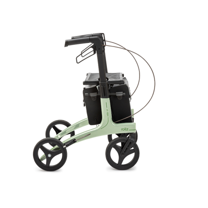 The Rollz Air Lightweight Folding Carbon Rollator weighs just 10.4 lbs and features a modern light green frame, four black wheels, black seat, black storage bags, and visible brake cables looped above the wheels.