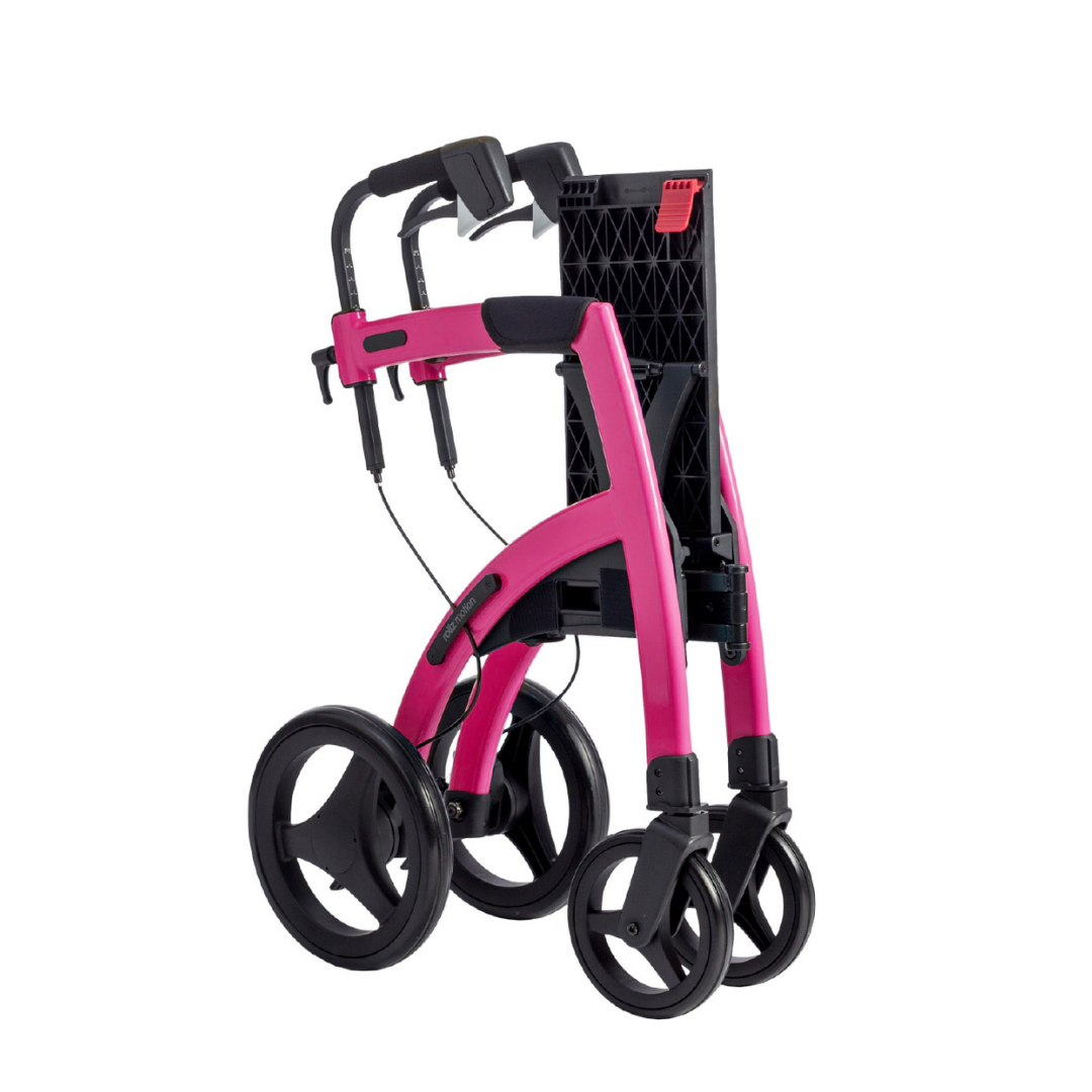 A compact, bright pink Rollz Motion 2-in-1 Rollator Walker and Wheelchair with black handles, large rear wheels, and smaller front wheels is shown folded against a white background.
