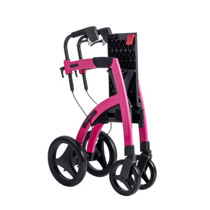 A compact, bright pink Rollz Motion 2-in-1 Rollator Walker and Wheelchair with black handles, large rear wheels, and smaller front wheels is shown folded against a white background.
