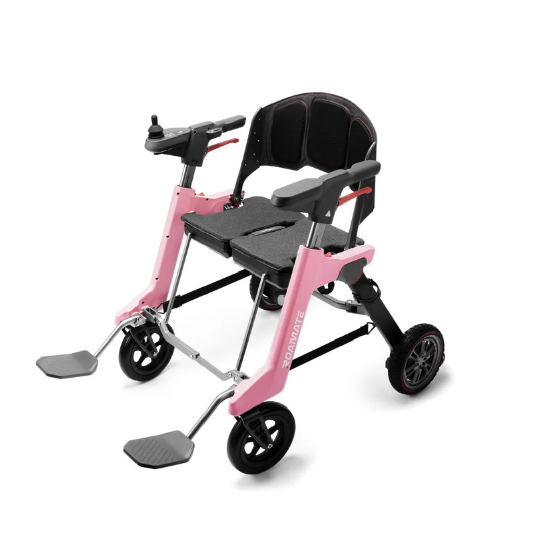 The Roamate 3-in-1 Electric Rollator Wheelchair is a lightweight, pink and black powered wheelchair with an armrest joystick, foldable footrests, and large rear wheels for versatile mobility.