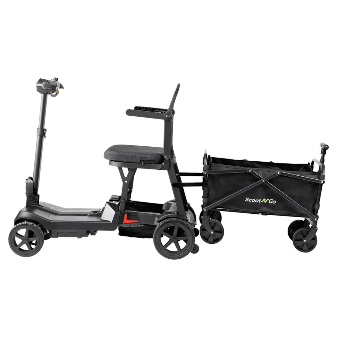 The ScootNGo Lite Portable Folding Scooter, black with four wheels, is shown attached to a compact black collapsible wagon for carrying extra cargo—see full product specs for details.