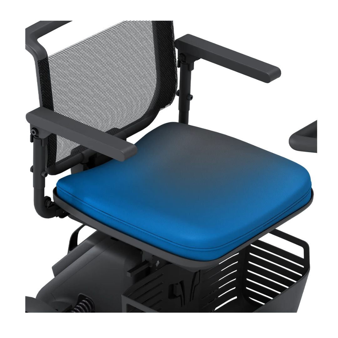 Close-up of the Seat Cushion For Whill Model R Scooters, shown installed with a padded cushion, black mesh backrest, two adjustable black armrests, and part of the seat base plus a partially visible black storage basket.