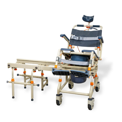The ShowerBuddy SB2T TubBuddy with Tilt is a beige and gray rolling shower chair with wheels, removable seat, armrests, footrests, transfer bench extension, blue headrest, and orange adjustment knobs for accessible bathing.