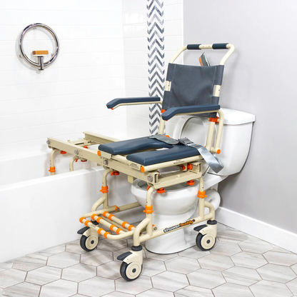 The ShowerBuddy SB2 TubBuddy Bathing System with Rolling Chair, shown in beige and gray with a padded seat, wheels, armrests, and backrest, straddles a toilet and extends over a bathtub for accessible bathing.