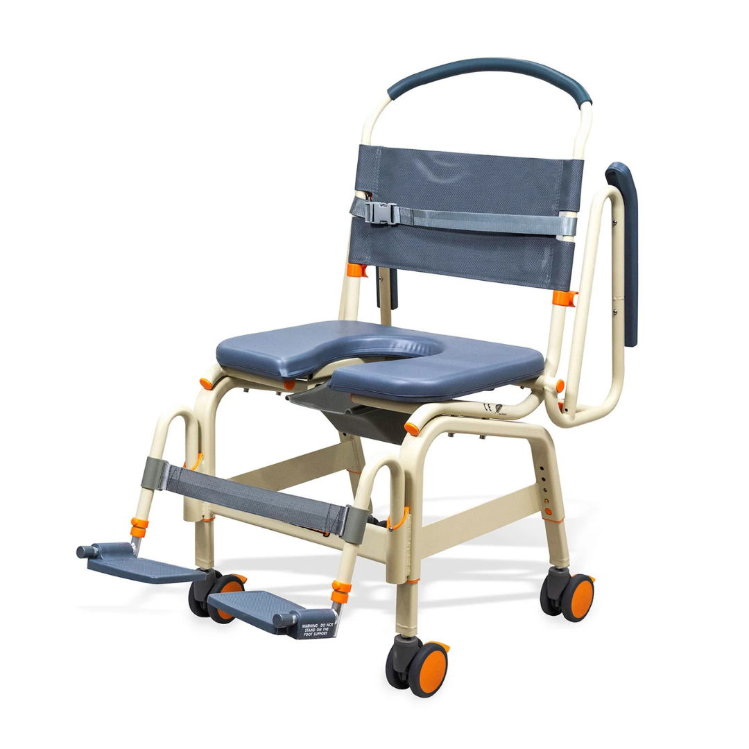 The ShowerBuddy SB6C Bariatric Rolling Shower Chair features a padded gray seat, armrests, backrest, adjustable footrests, four wheels with orange accents for mobility, safety straps, and accessible design for patient care.
