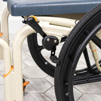 Close-up of the ShowerBuddy SB6W Roll-In Shower Wheelchair, highlighting its wheel and brake lever on a tiled floor—perfect for accessible spaces near roll-in showers or when used with a shower chair.