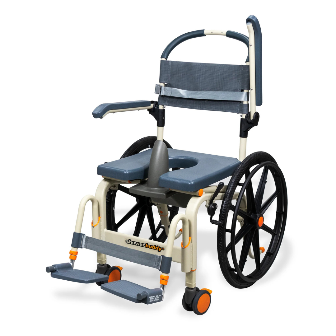 The ShowerBuddy SB6W Roll-In Shower Wheelchair is a gray and beige self-propelled shower and commode chair with large rear wheels, small front casters, a padded seat opening, armrests, and footrests.