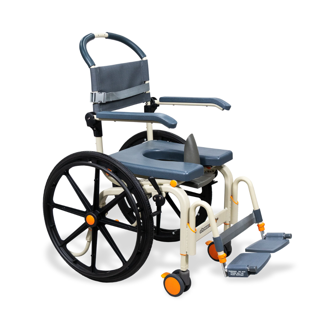 The ShowerBuddy SB6W Roll-In Shower Wheelchair is a gray and white, self-propelled chair with large rear wheels, small front wheels, armrests, footrests, an open seat for toileting or showering, and orange accents on the frame and wheels.
