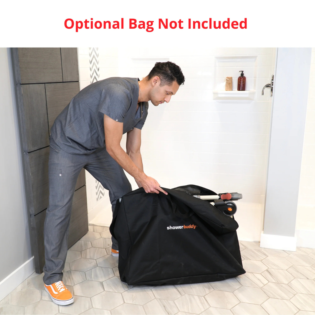 A man in gray scrubs zips a large black bag labeled ShowerBuddy, designed for the SB7e Folding Shower Chair, in an accessible shower bathroom. Red text above states: Optional Bag Not Included.