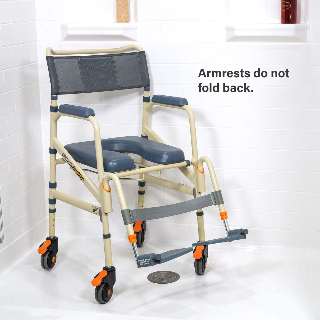 A ShowerBuddy SB7e Folding Shower Chair in beige and gray, with wheels and footrests, is positioned in a white tiled accessible shower. Text on the wall states: Armrests do not fold back.